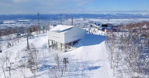 Aerial view of ski slope, ski resort, ski lift elevator, and cityscape. Russia Stock Footage 88485828