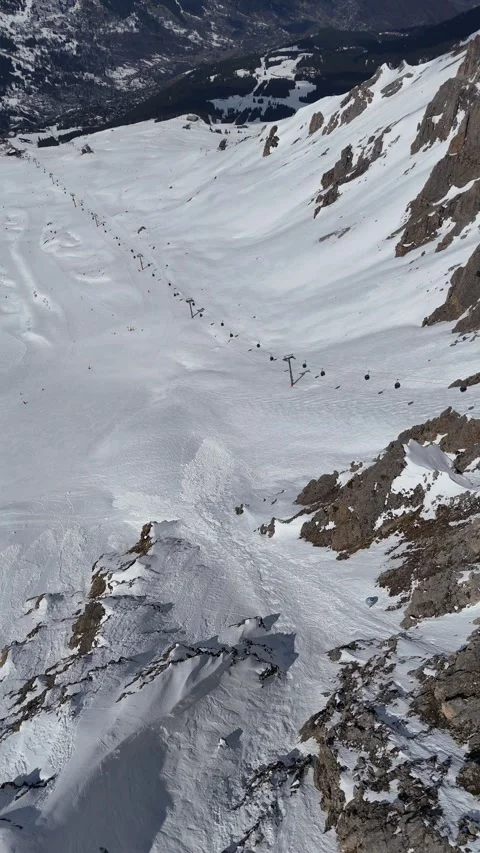 Aerial view of ski slopes in the mountains by winter Stock Footage 336178450