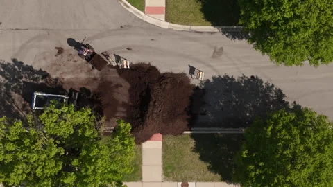 Aerial view of Skid steer loader transporting fresh mulch during residential Stock Footage 335968808