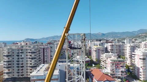 Aerial View: The skilled operator assembles crane parts and climbs high ladders Vídeo Stock 296021871