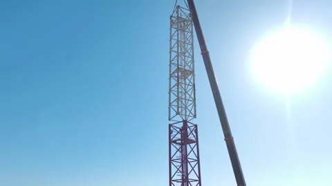 Aerial View: Skilled operator mounts parts of a large crane and navigates Vídeo Stock 296021076