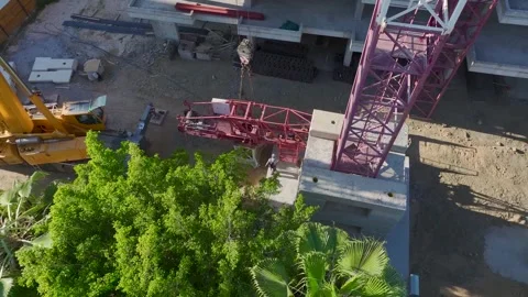 Aerial View: Skilled operator scales ladders and assembles crane parts on a Vídeo Stock 296022879