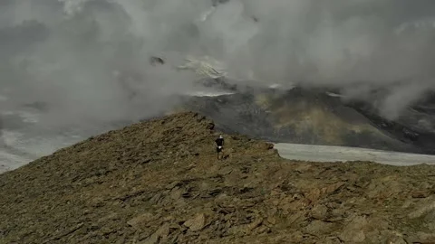 Aerial view of sky-runner running high in the mountains. Stock Footage 138577308