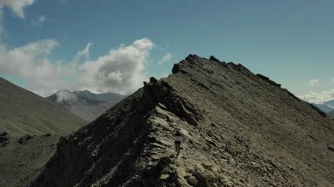 Aerial view of sky-runner running high in the mountains. Stock Footage 138578367