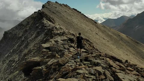 Aerial view of sky-runner running high in the mountains. Stock Footage 140973914
