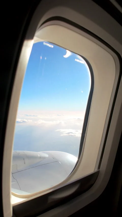 Aerial view of sky through a window of an airplane, Vertical video Stock Footage 321375638