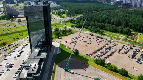 Aerial view: a skyscraper and a mobile crane with a fully extended boom. Video stock 147044024