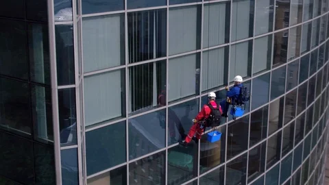 Aerial view of the skyscraper and window cleaners washing the windows Stock Footage 93343225