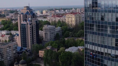 Aerial view of the skyscraper and window cleaners washing the windows Stock Footage 93345572