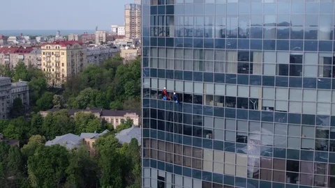 Aerial view of the skyscraper and window cleaners washing the windows Stock Footage 93345732
