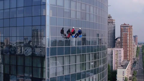 Aerial view of the skyscraper and window cleaners washing the windows Stock Footage 93347643