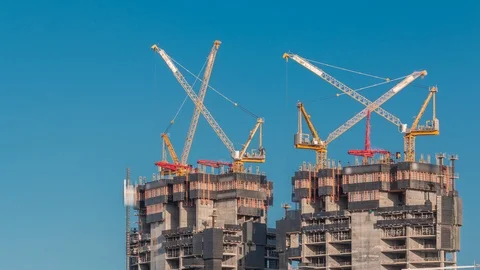Aerial view of a skyscraper under construction with huge cranes timelapse in Stock Footage 124846787