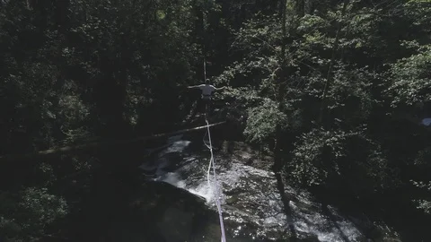 Aerial View of Slackliner over Lush Creek Stock-Footage 81844547