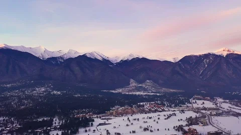 Aerial view slide of a mountain range background of a crimson sky. Ski resort Stock Footage 103315229