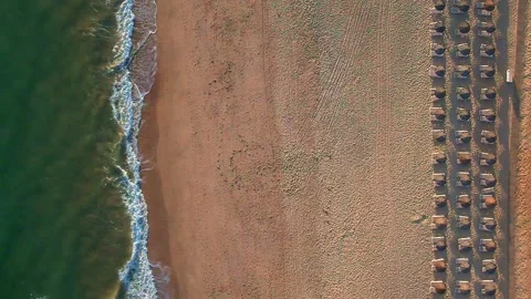 Aerial view slow motion Closeup topdown view of beach parasols near waves  Stock Footage 195938800
