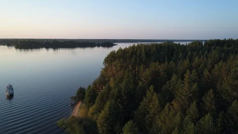 Aerial view. A small boat is anchored in a beautiful picturesque bay at sunset. Stock Footage 97856341