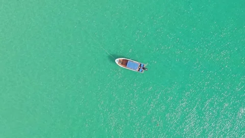 Aerial view of small boat drifting on turquoise water in tropical setting Video stock 337418535