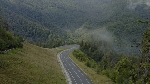 Aerial view small bus driving in mountain road with low clouds Stock Footage 118723950