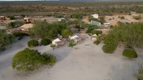 Aerial view of small cabins surrounded by bushes on a paradisiacal beach Stock-Footage 271617744