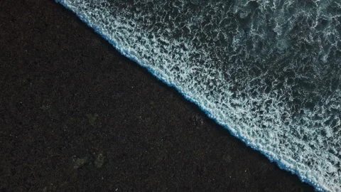 Aerial view of small coastal waves over black sand beach. Nusa Bali, Indonesia Stock Footage 316648889