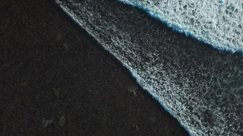 Aerial view of small coastal waves over black sand beach. Nusa Bali, Indonesia Stock Footage 316648937