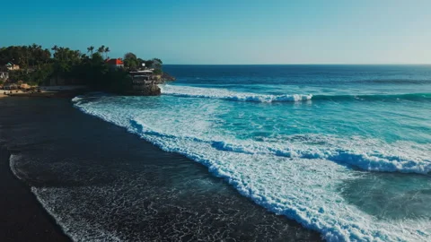 Aerial view of small coastal waves over black sand beach. Nusa Cenigan Bali Stock Footage 316649241