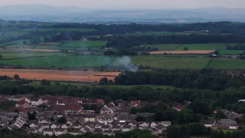 Aerial View of Small Fire and Smoke Across Rural Landscape Near Homes Stock Footage 344473367