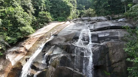 Aerial view of a small mountain  through rocks and lush green forest. Stock Footage 340594573