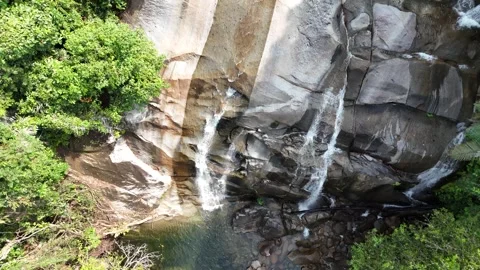 Aerial view of a small mountain  through rocks and lush green forest. Stock Footage 340594577