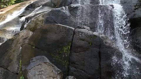 Aerial view of a small mountain  through rocks and lush green forest. Stock Footage 340594580
