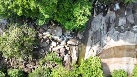 Aerial view of a small mountain  through rocks and lush green forest. Stock Footage 340594582
