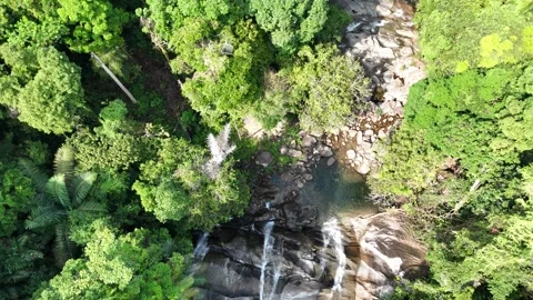 Aerial view of a small mountain  through rocks and lush green forest. Stock Footage 340594604
