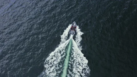 Aerial view of Small open boat moving across dark blue water. south wales uk Stock Footage 192565731