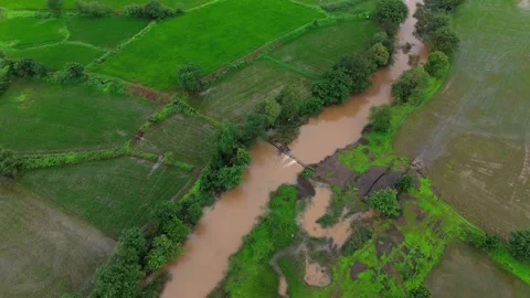 Aerial View of a Small River Flowing Through Lush Green Grassland Видео 342701475