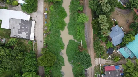 Aerial view of a small rural river canal surrounded by green trees and foliage. Stock Footage 342952353