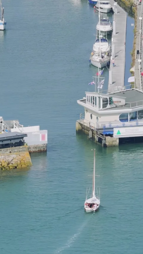 Aerial view of a small sailboat navigating into the marina at Binic port Stock Footage 346663599