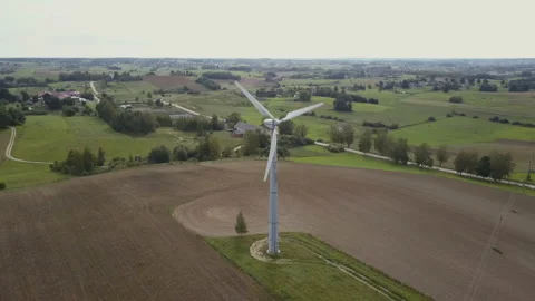 Aerial view of small single wind turbine rotating fast. Summer countryside with Stock Footage 102699149