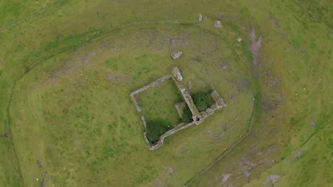 An aerial view of a small stone building in a grassy field Stock Footage 328536481