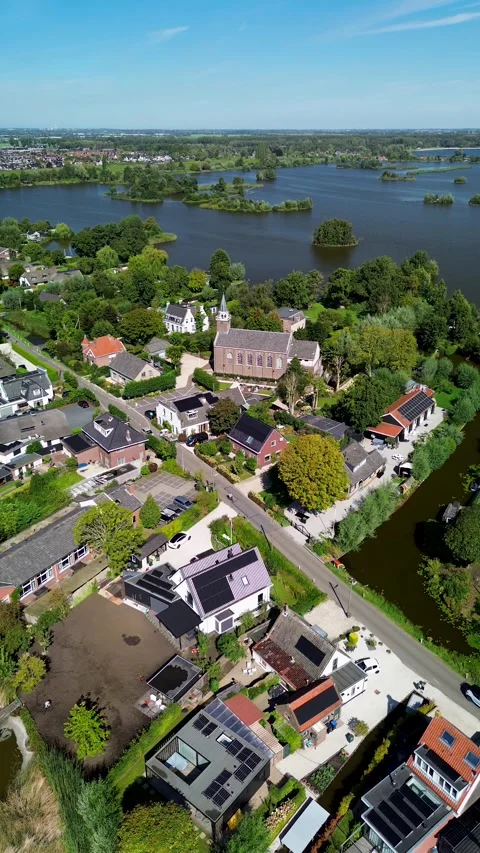 Aerial view of a small town with a central church and tall steeple, surrounded Stock-Footage 317447562