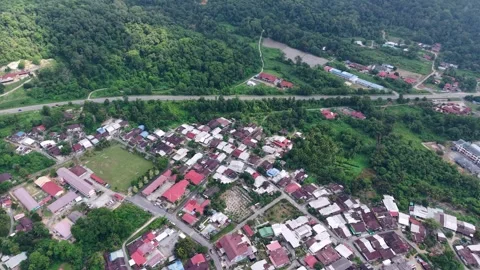 Aerial view of small town with dense houses and green forested hills Vídeos de archivo 344899622