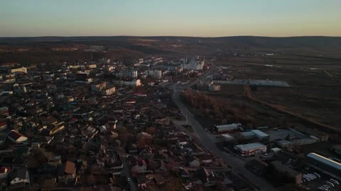 Aerial view of a small town during sunset, showcasing rooftops, streets, and Vídeo Stock 332723732