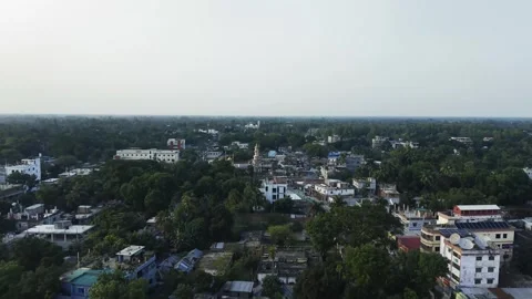 Aerial view of a small town with low-rise buildings, dense green trees and .. Vidéo 338302265