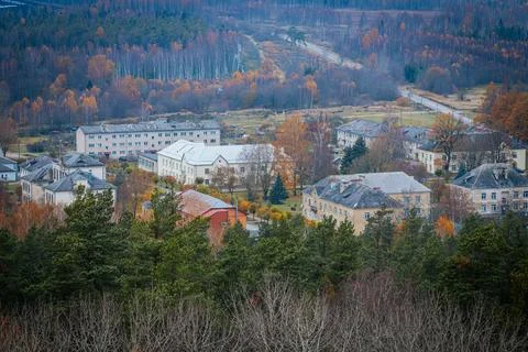 Aerial view of a small town nestled within a vast autumn forest Stock Photos