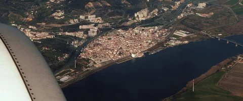Aerial view of small town by the river from the window of an airplane Stock Footage 127135427