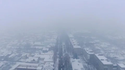 Aerial view of small town in snowfall. Blizzard. Snowstorm. Stock Footage 120784776