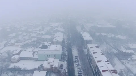 Aerial view of small town in snowfall. Blizzard. Snowstorm. Stock Footage 120784946