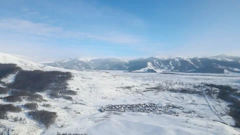Aerial view of a small village nestled in a snowcovered mountain valley Video stock 341908592