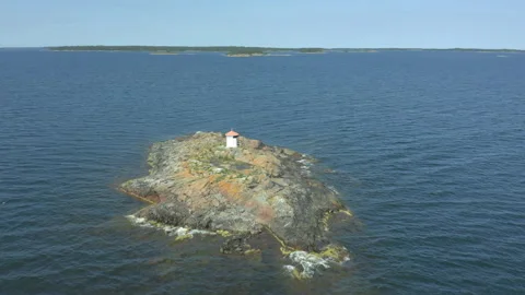 Aerial view of a small washed lighthouse on a remote island, cinematic footage Stock Footage 134177535