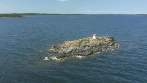 Aerial view of a small washed lighthouse on a remote island Stock Footage 134177626