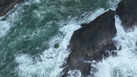 Aerial View of a Small Waterfall Flowing Off the Oregon Coast into the Ocean Stock Footage 292694299
